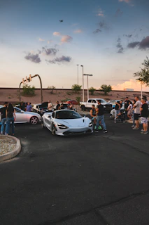 A group of automotive creators collaborating outdoors with cameras and drones.