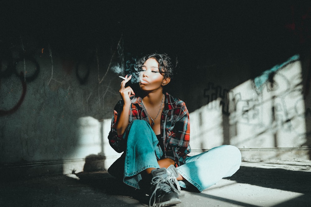 woman in red and blue plaid button up shirt and blue denim jeans sitting on floor