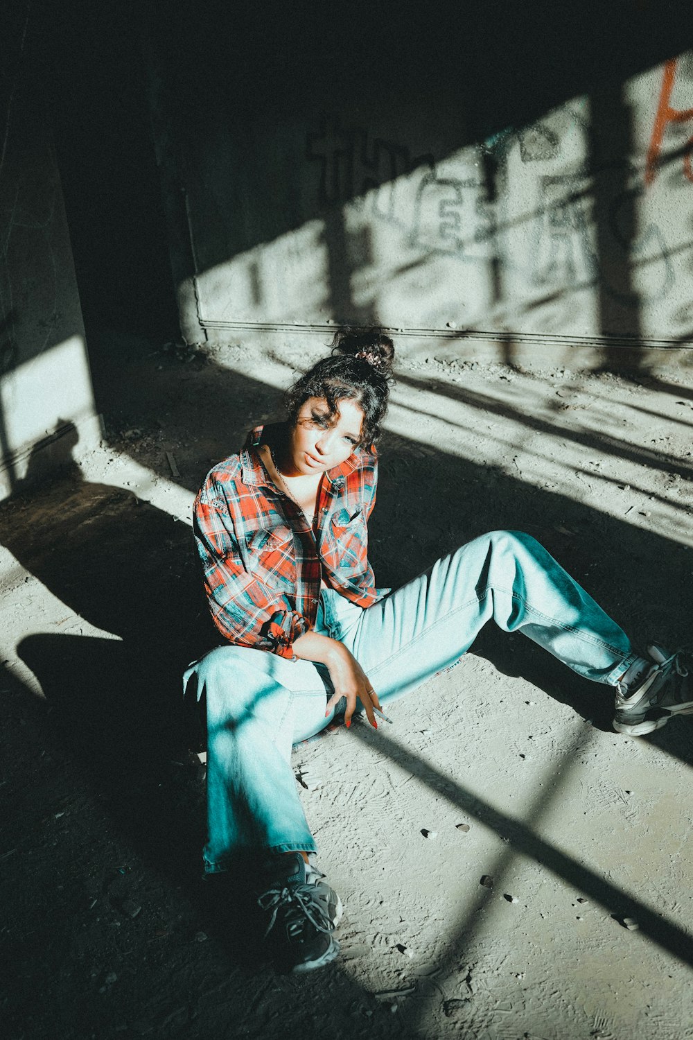 woman in blue denim jeans sitting on concrete wall