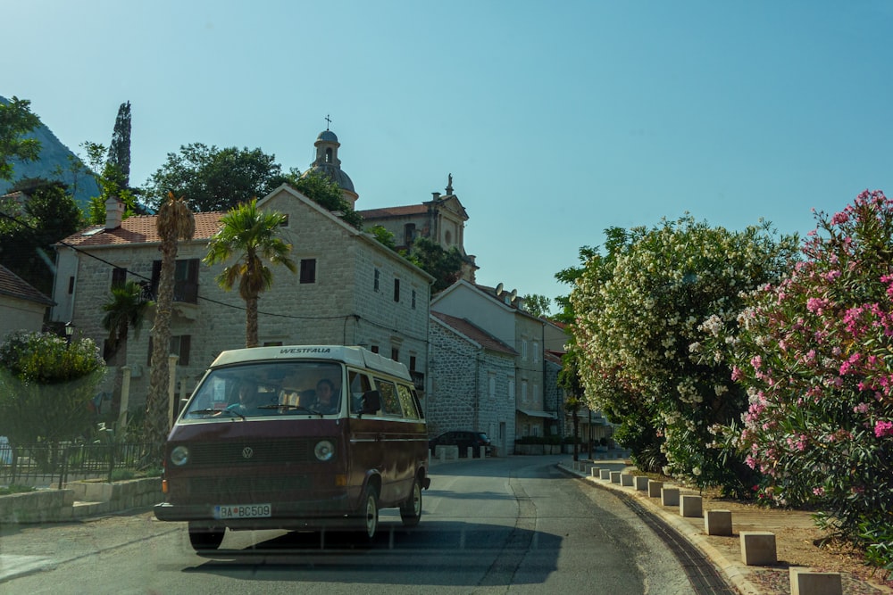 brown van parked on roadside near green trees during daytime