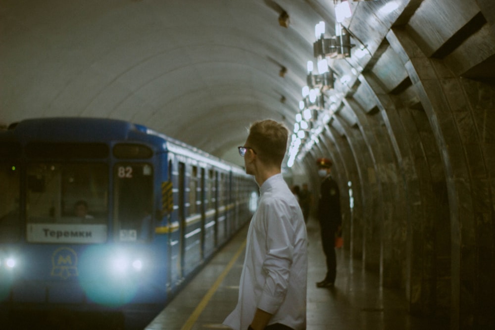 man in white dress shirt standing on white hallway