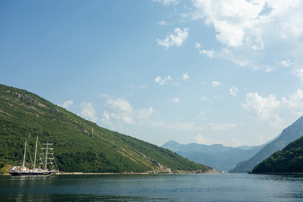 green mountains near body of water under blue sky during daytime