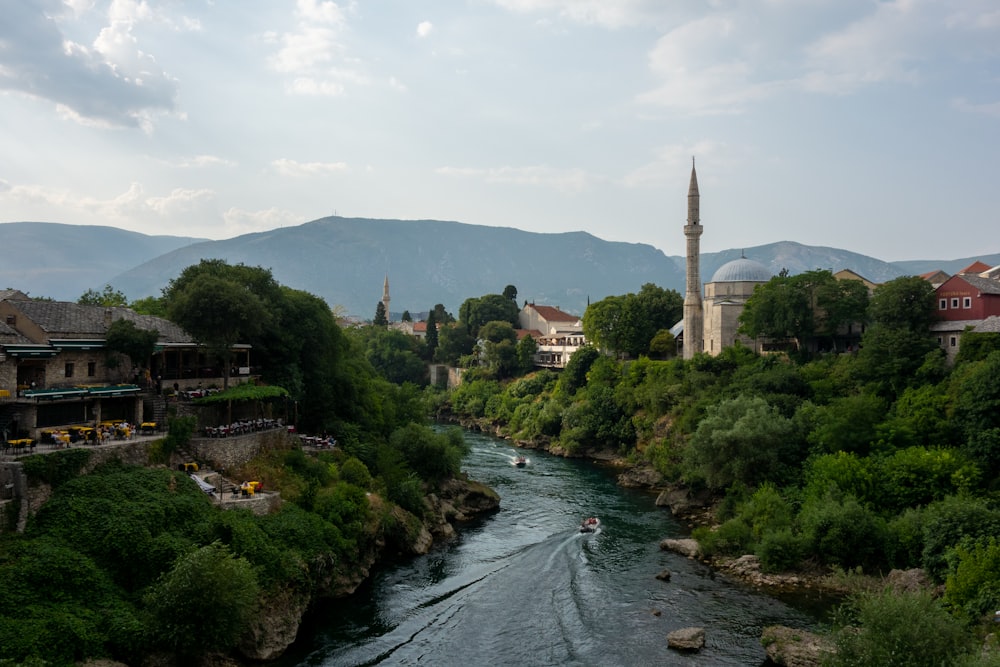 river between green trees and brown concrete building during daytime