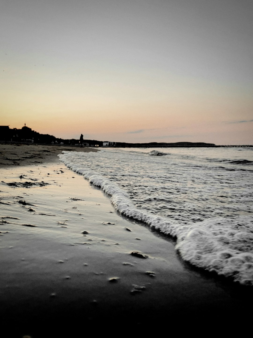 sea waves crashing on shore during sunset