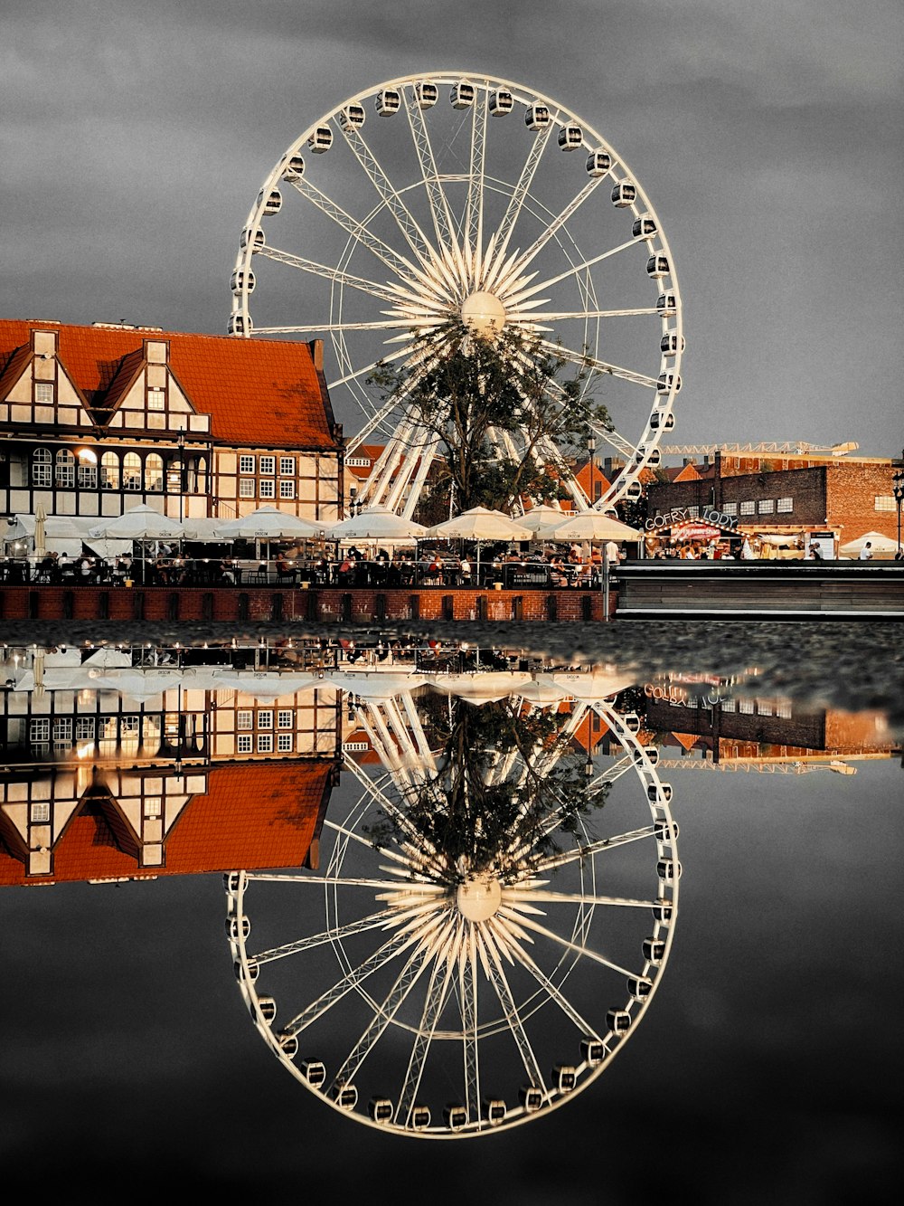 ferris wheel near brown building during daytime