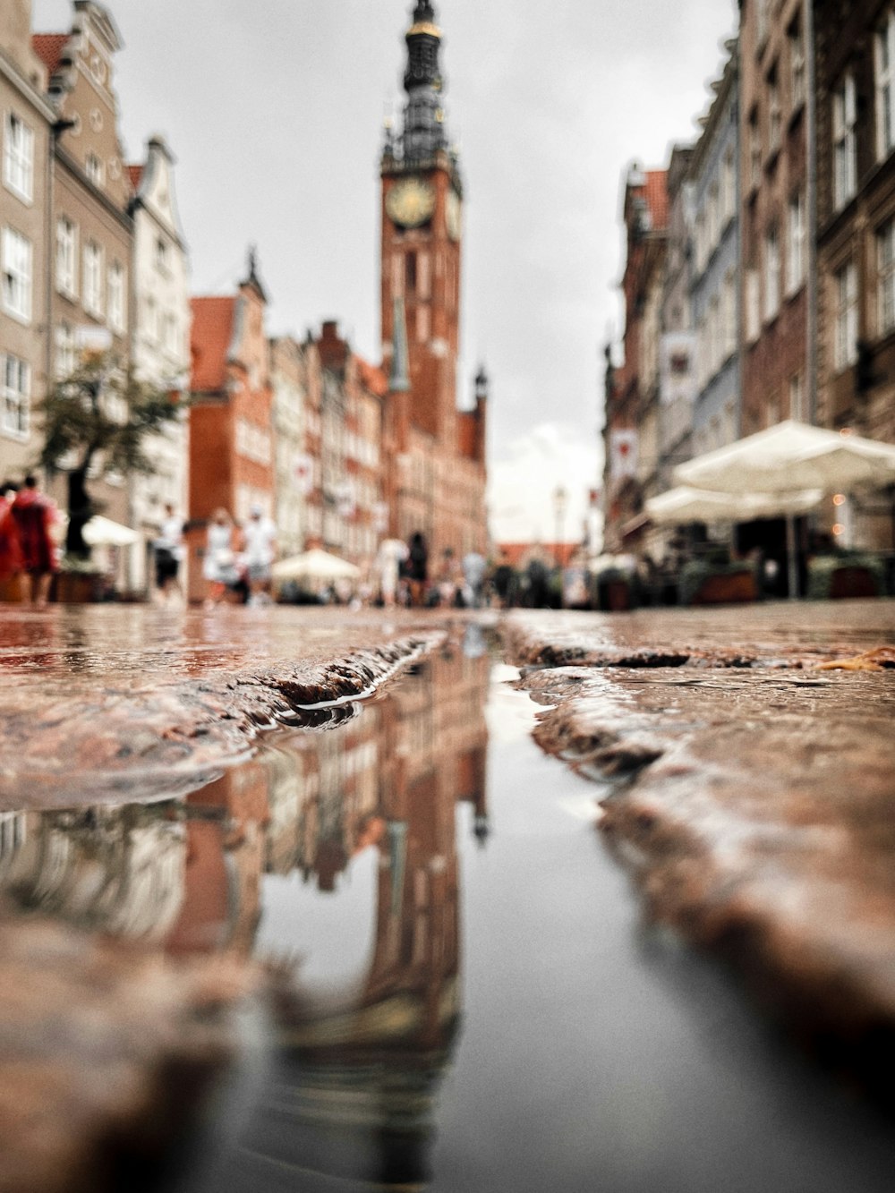 water on road between buildings during daytime