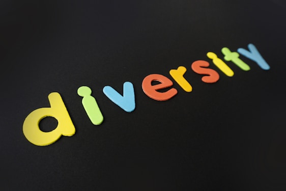 Colorful letters spell out the word 'diversity' against a dark background. Each letter is a different vivid color, creating a striking contrast.
