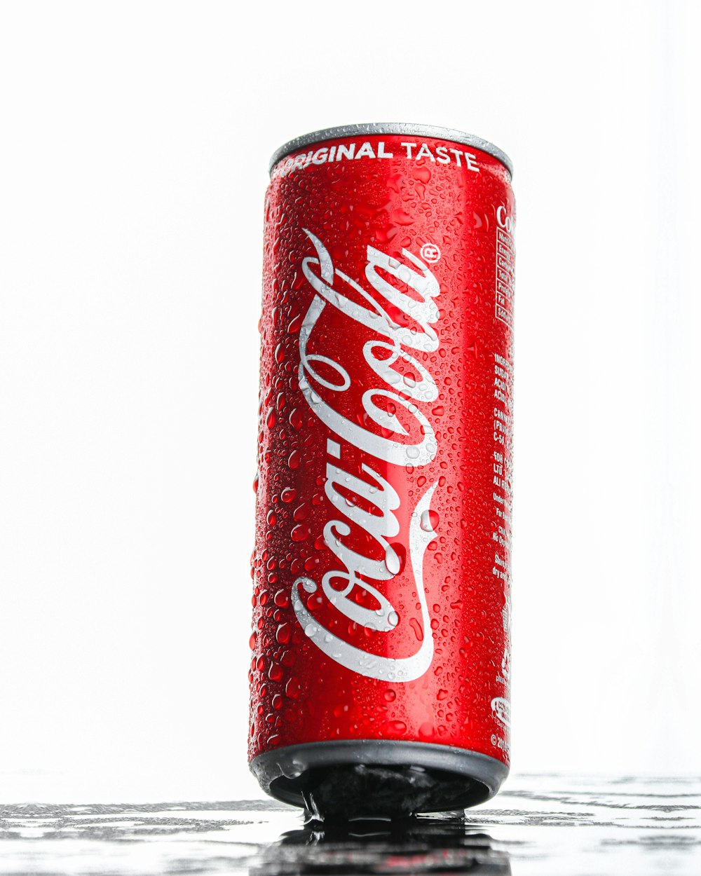 Lata de Coca Cola sobre superficie blanca