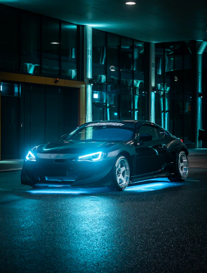 Sleek tow truck illuminated by neon blue lights at night, showcasing JK Auto Socorro's modern fleet.
