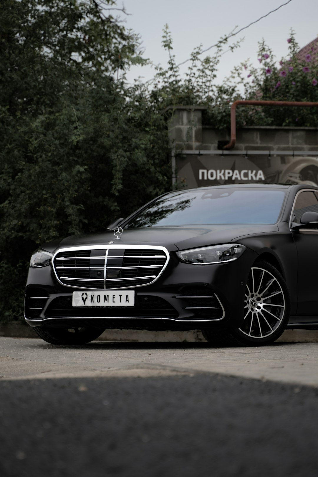 black mercedes benz c class parked near green tree during daytime