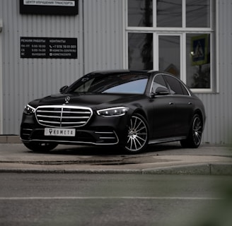 black mercedes benz coupe parked near white building