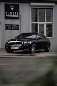 black mercedes benz coupe parked near white building