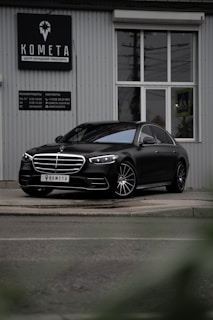 black mercedes benz coupe parked near white building