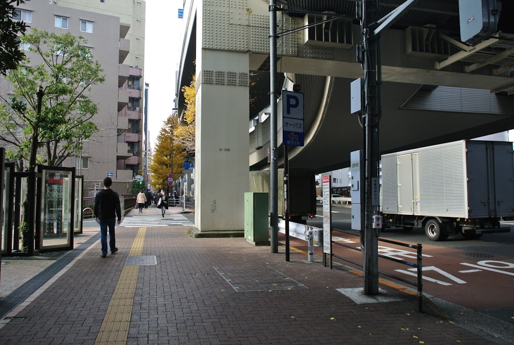 people walking on sidewalk near building during daytime