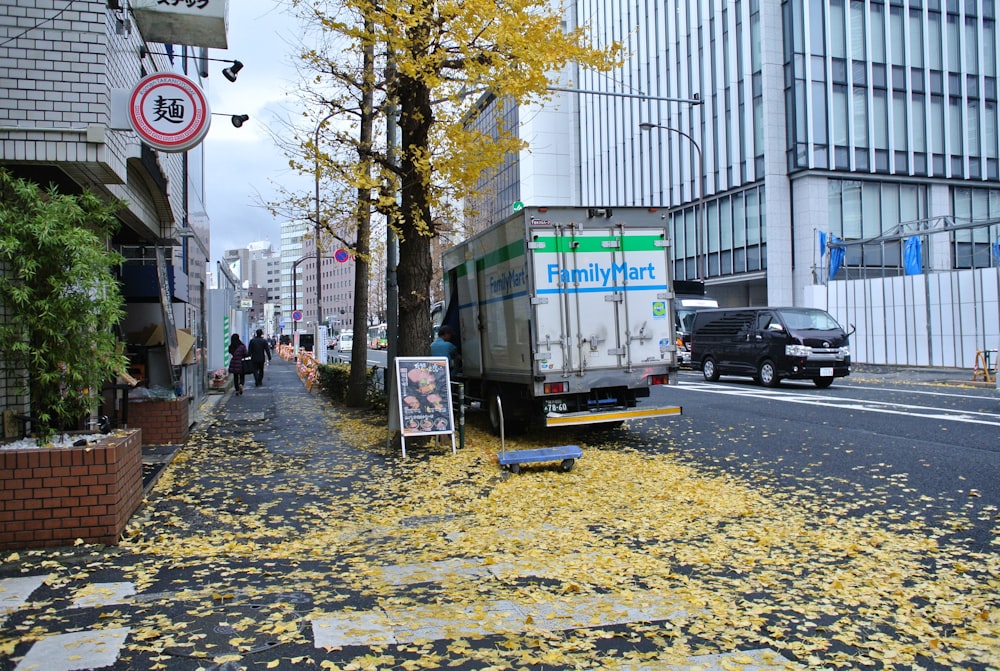 낮 동안 녹색 나무 근처의 녹색과 노란색 트럭