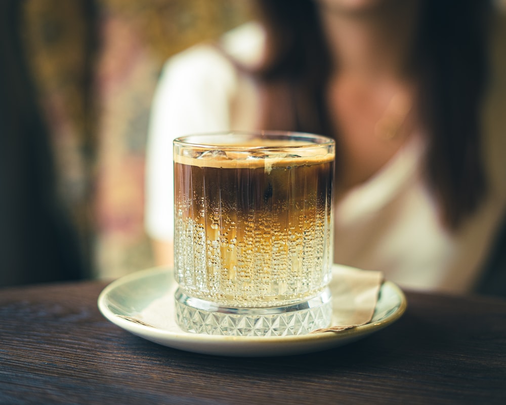 clear glass mug on white ceramic saucer