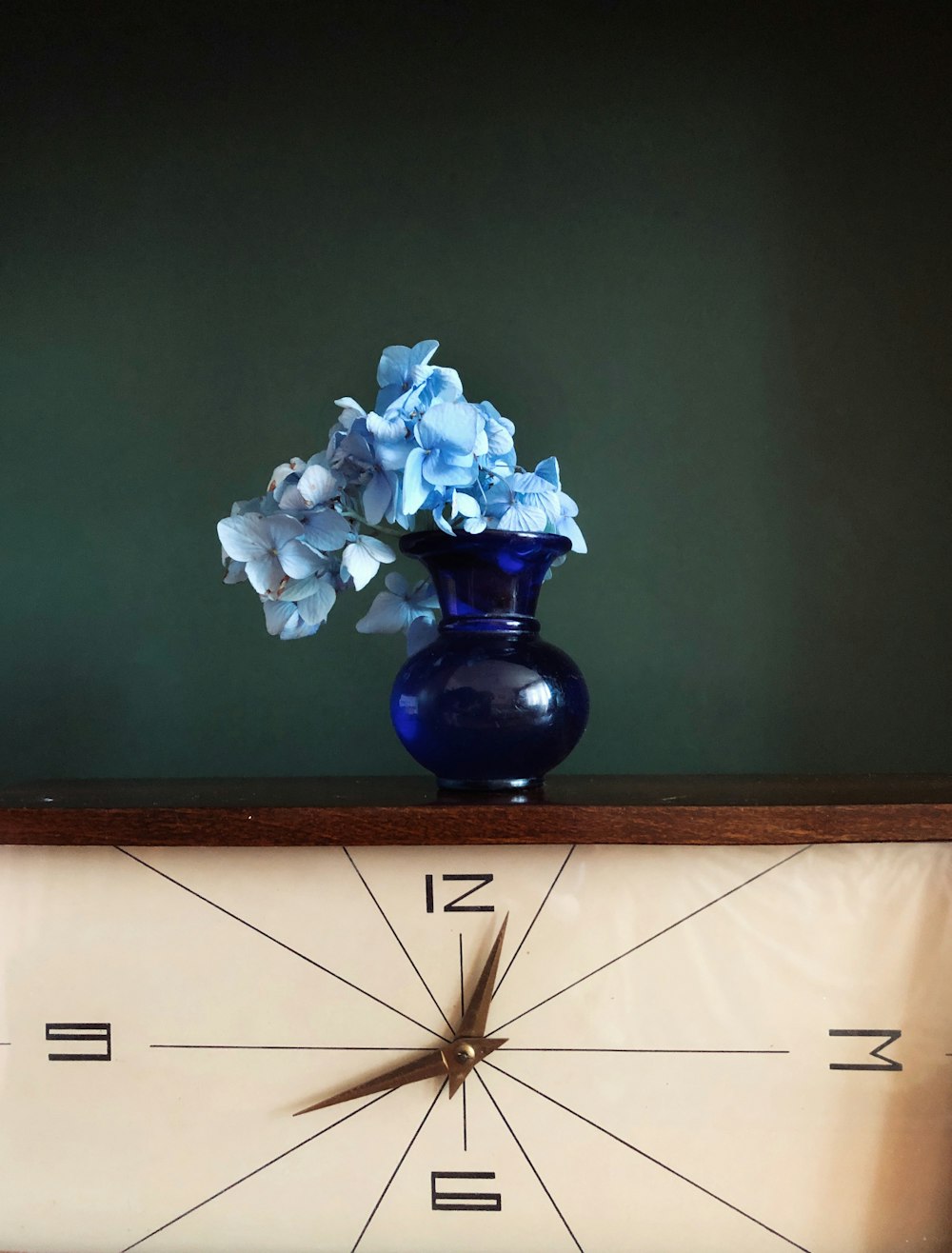 white flowers in blue glass vase