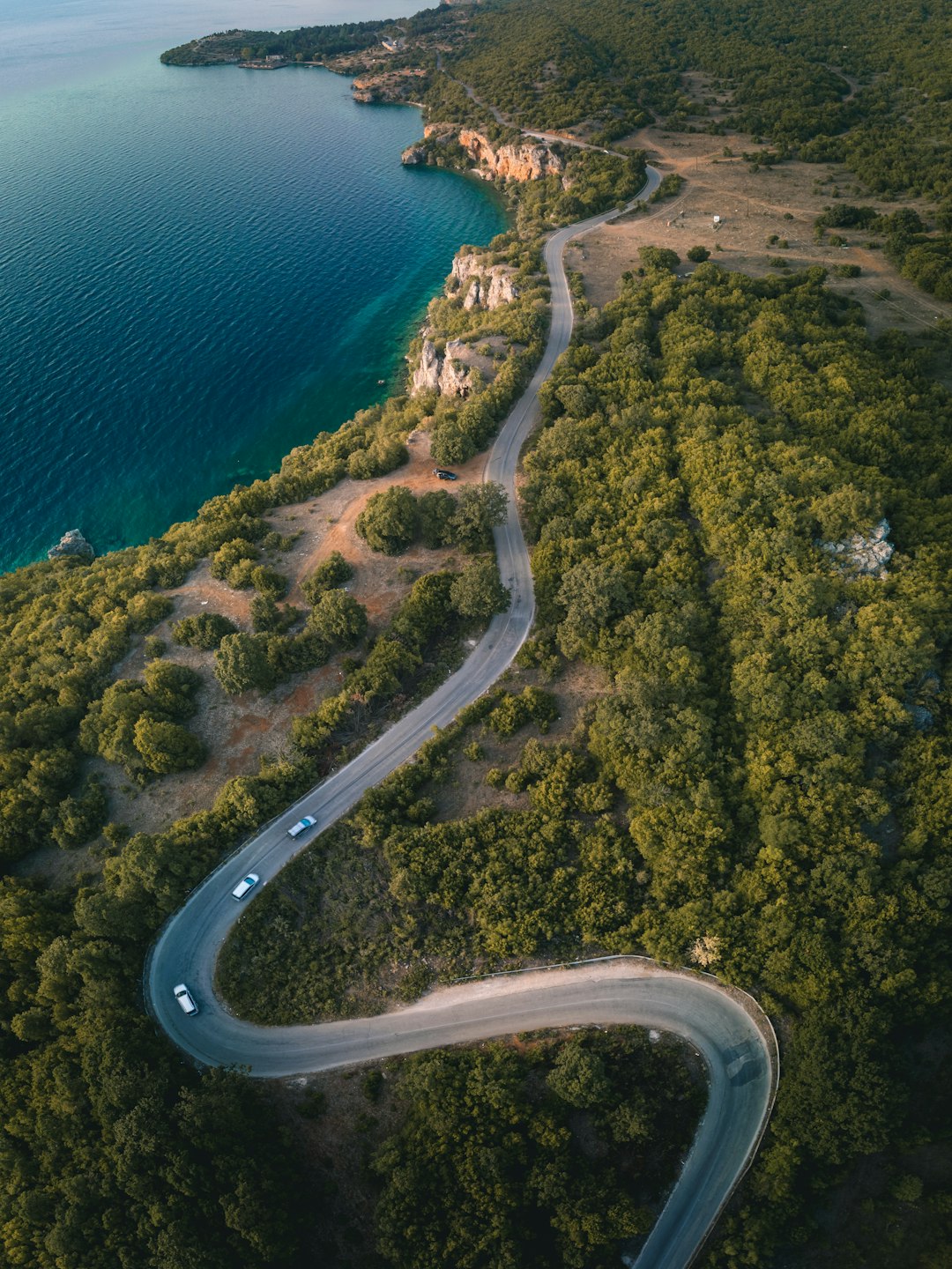 aerial view of road near body of water during daytime