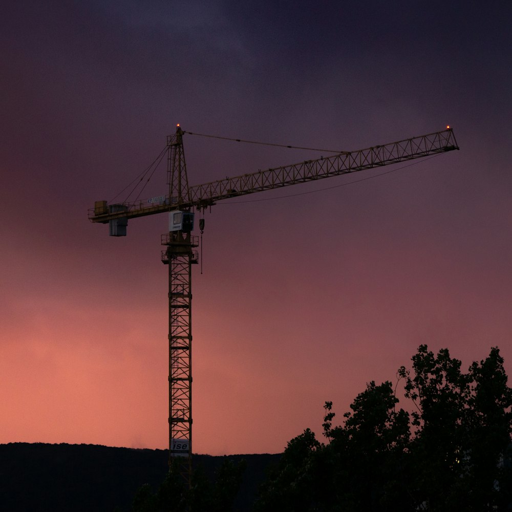 silhouette of crane under cloudy sky during daytime