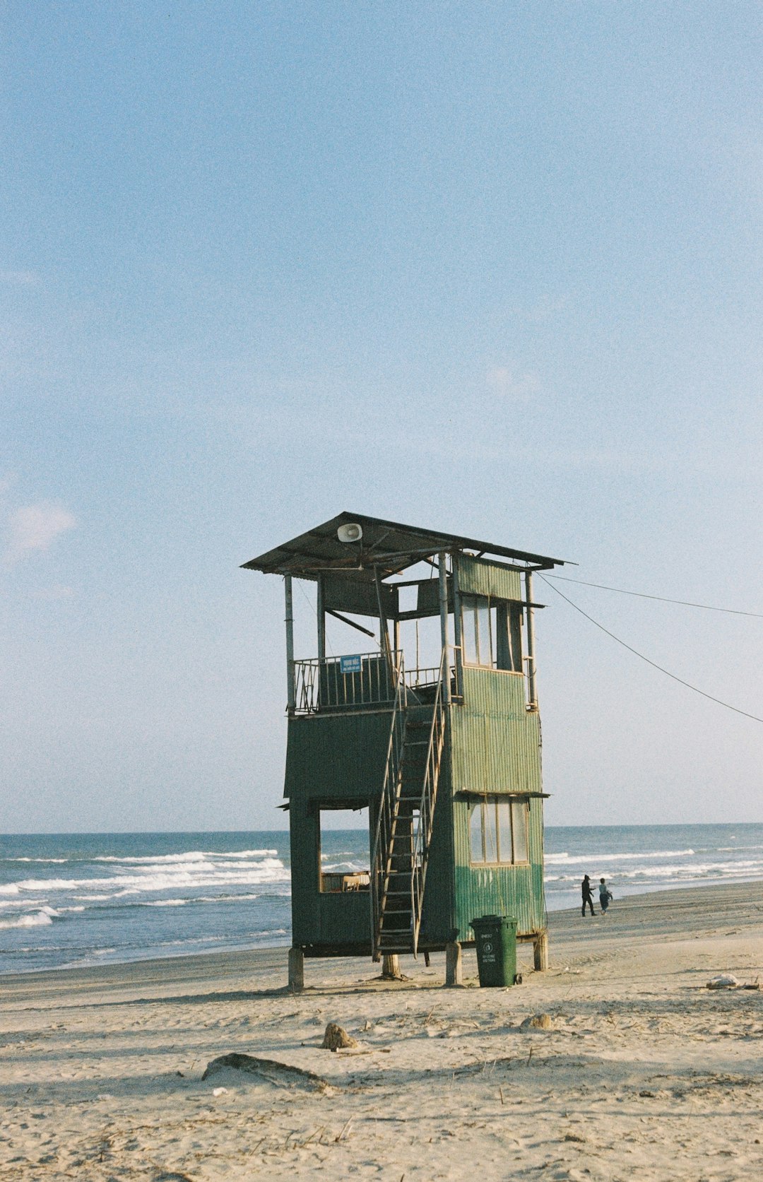 green wooden house on beach during daytime