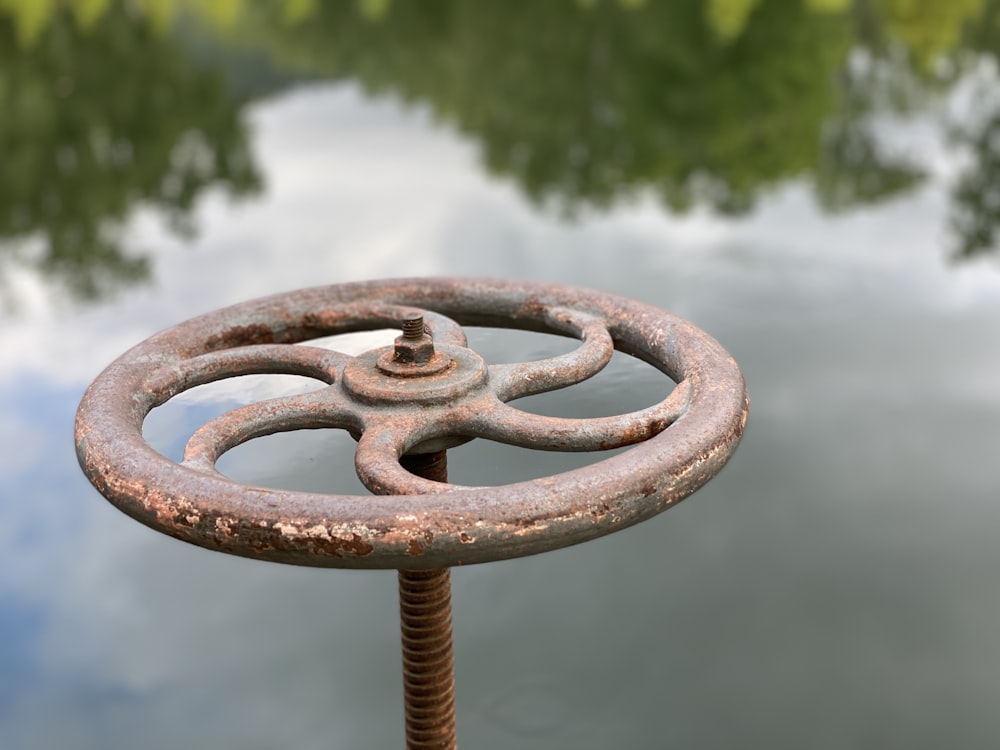 brown metal round ornament near body of water during daytime