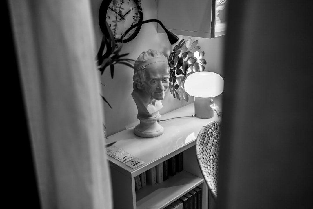 grayscale photo of 2 women figurine on table