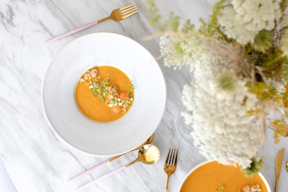 white ceramic plate with stainless steel fork and knife