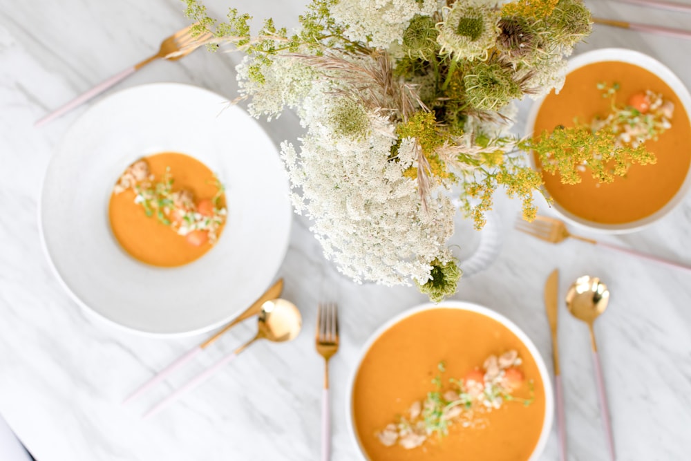 white ceramic plate with orange soup