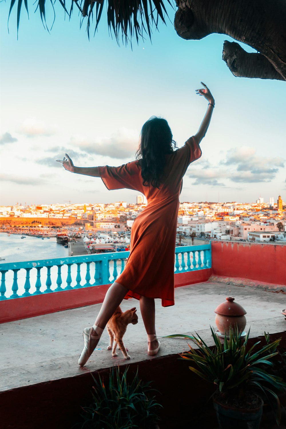 woman in orange dress standing on red concrete floor during daytime