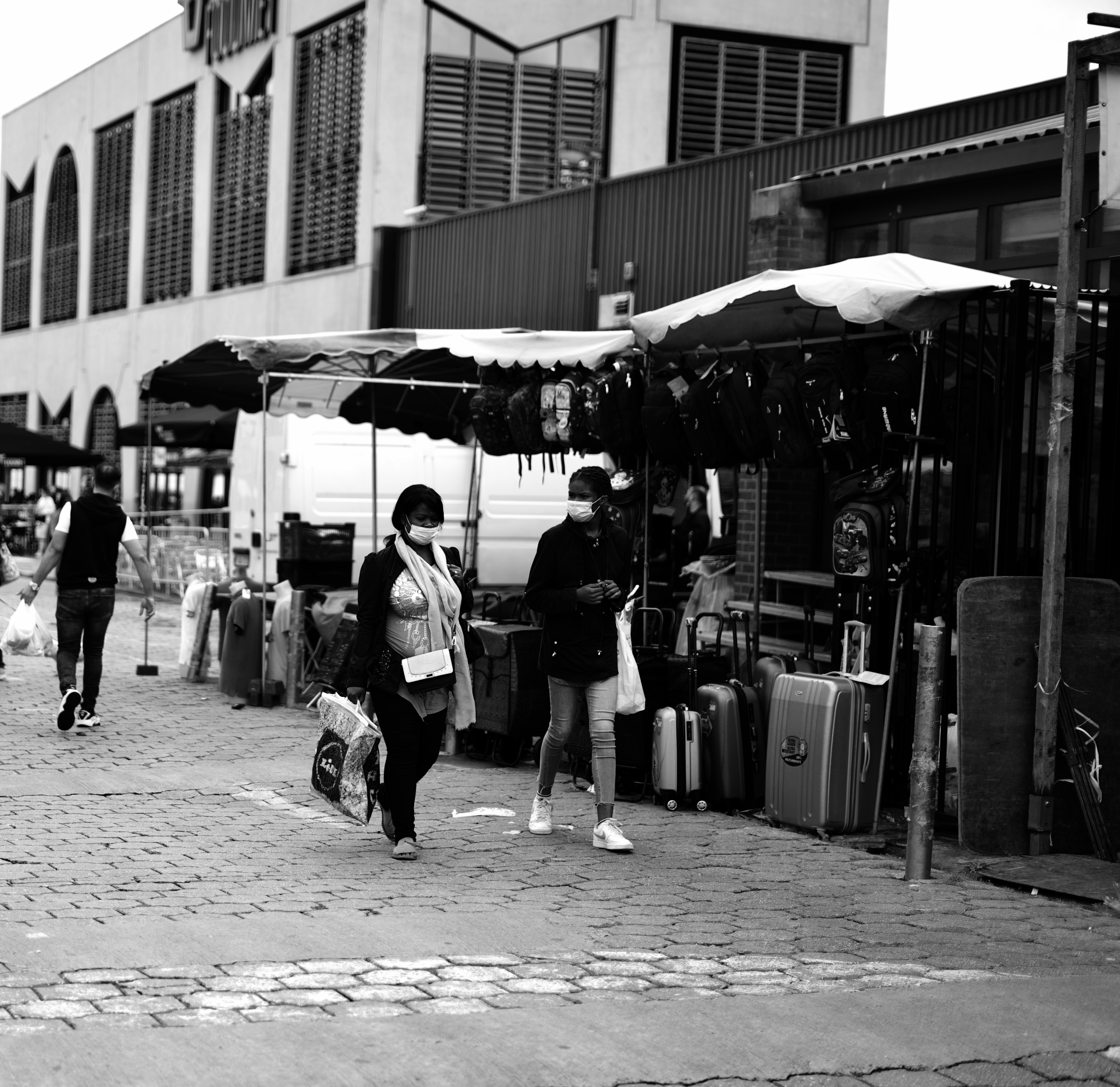 grayscale photo of people walking on sidewalk during daytime