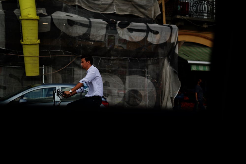 man in white t-shirt and black pants sitting on black motorcycle