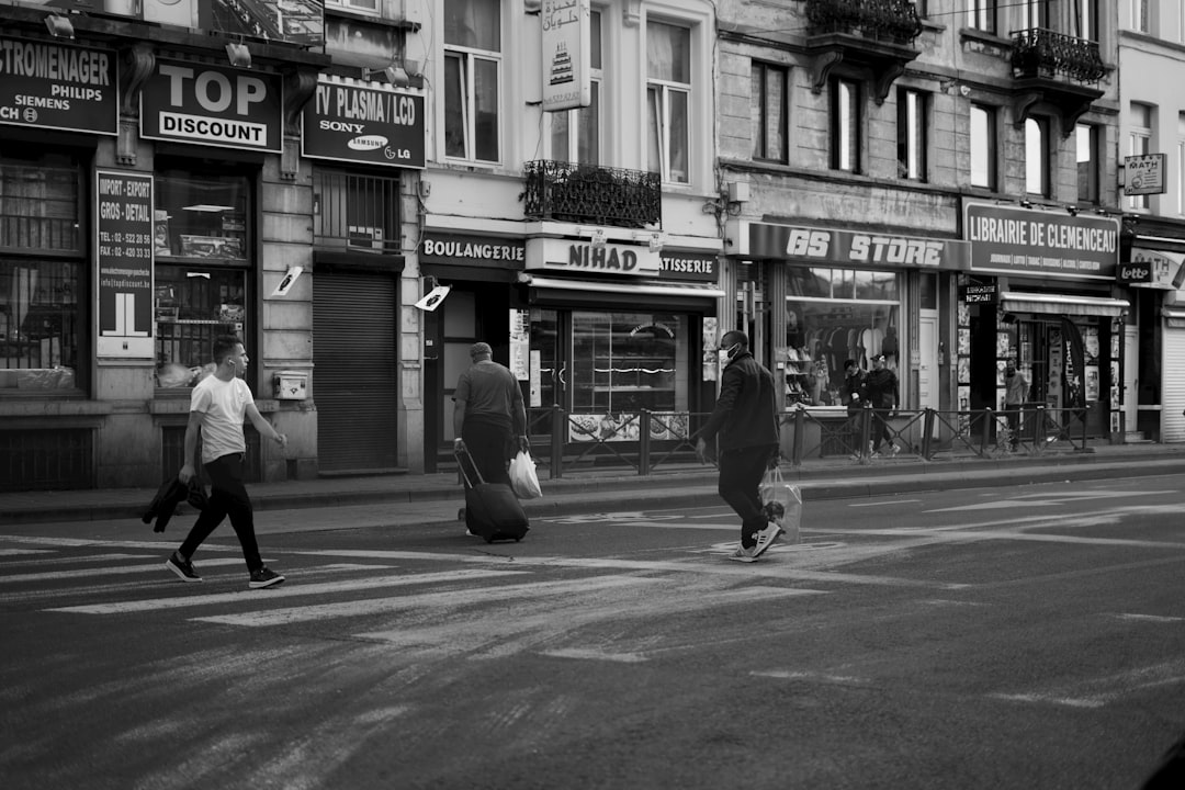 grayscale photo of people walking on sidewalk