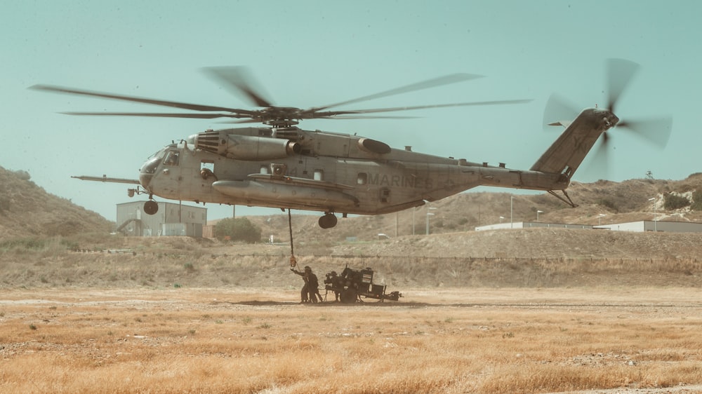 gray helicopter on brown field during daytime