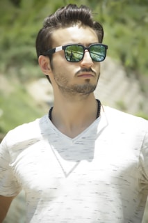 man in white v neck shirt wearing black sunglasses