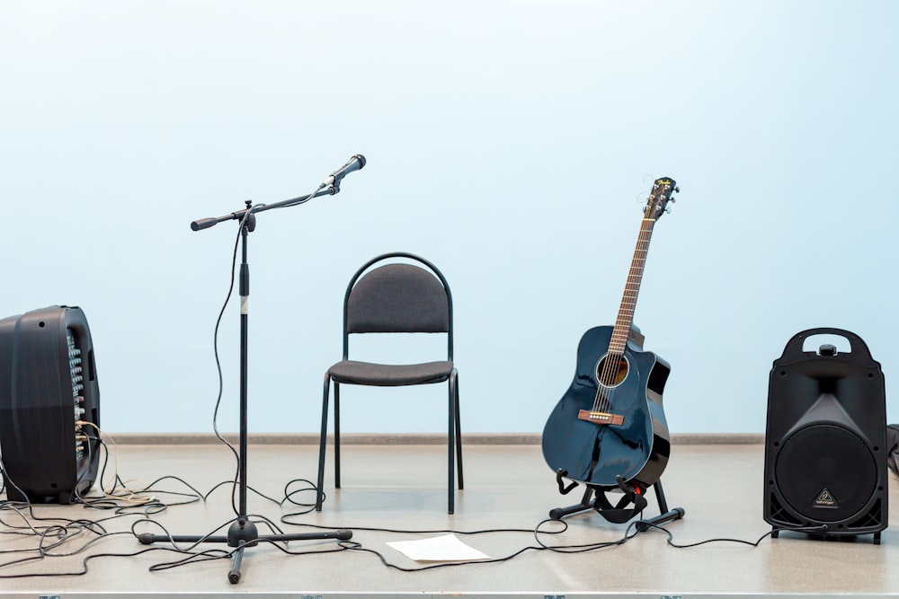 black acoustic guitar on black steel chair