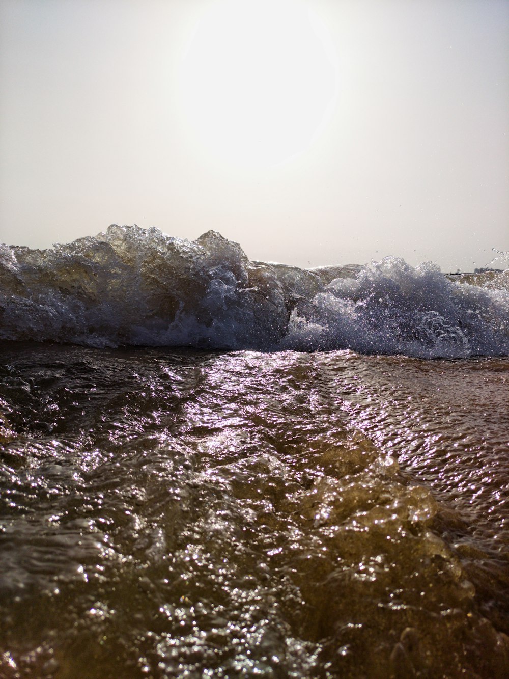 gray rock formation on body of water during daytime