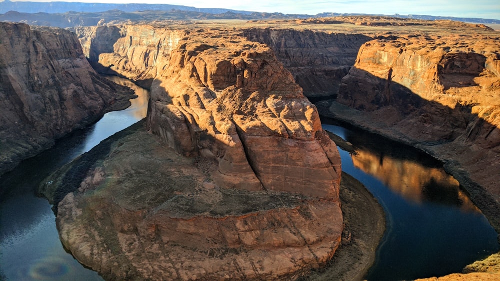 brown rock formation near body of water during daytime