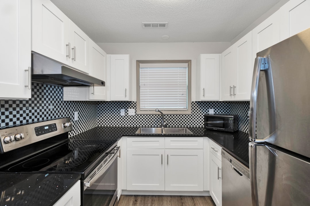 white wooden kitchen cabinet and black microwave oven