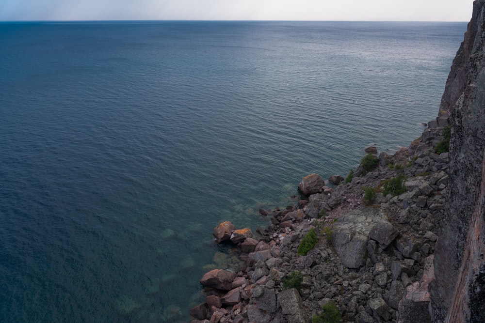 brown rocks beside body of water during daytime