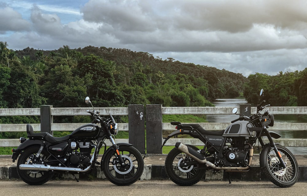 black cruiser motorcycle parked beside wooden fence