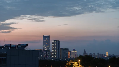 Evening city skyline with financial district buildings lit up.