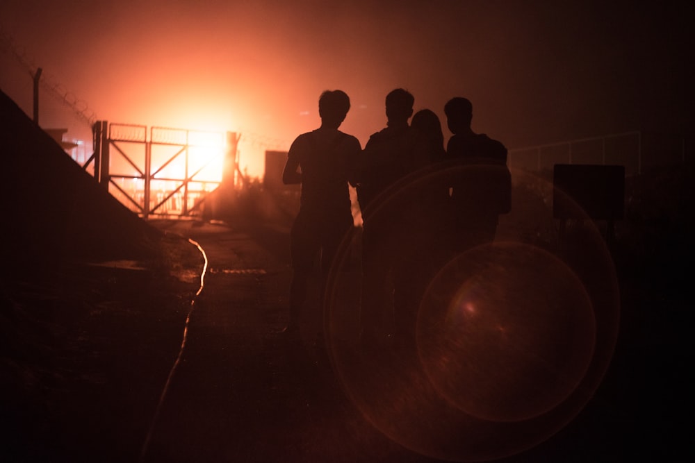 silhouette of people standing near tunnel during sunset