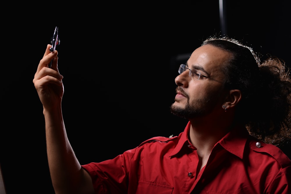 man in red button up shirt smoking cigarette