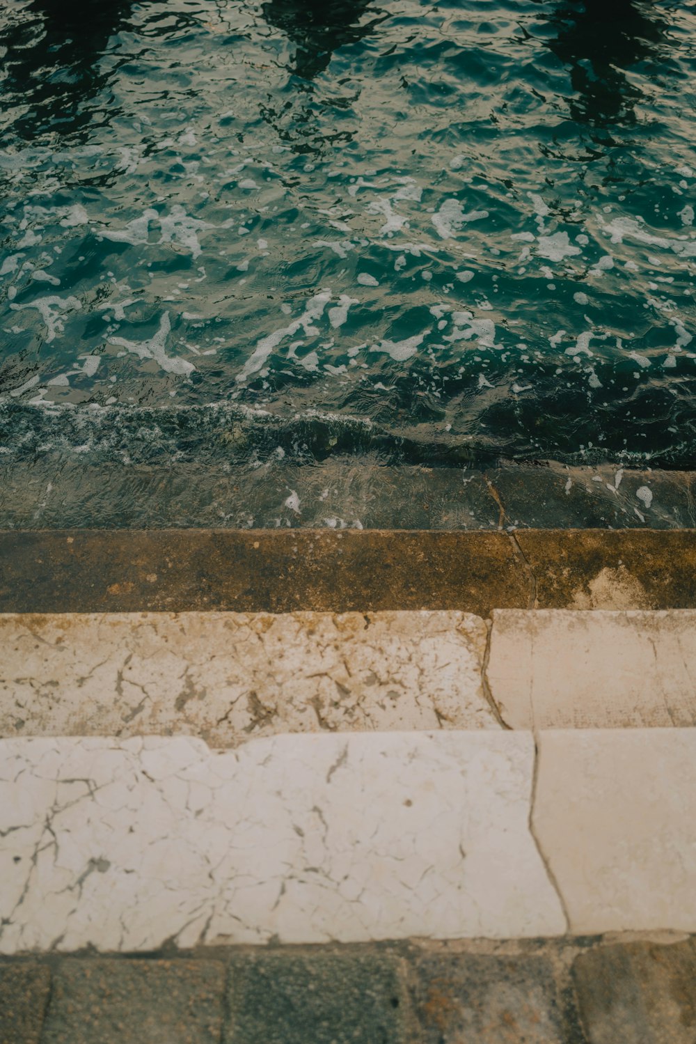 Specchio d'acqua vicino a un muro di cemento grigio