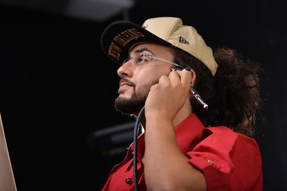 man in red polo shirt wearing brown hat