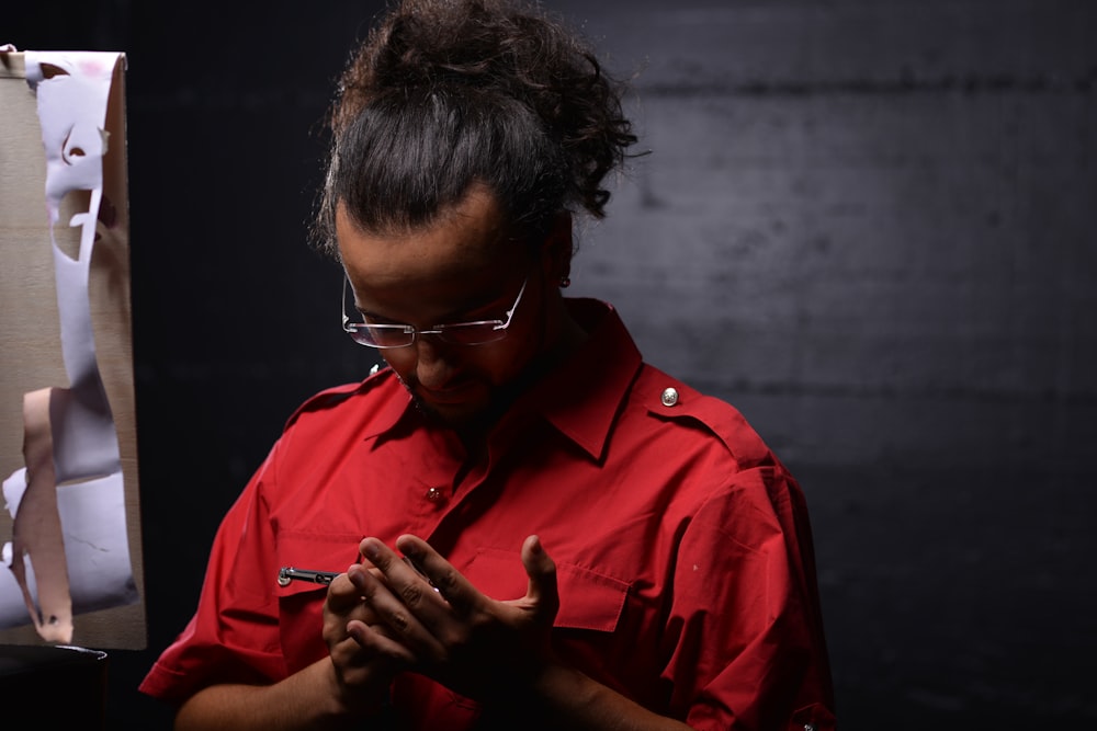 man in red button up shirt wearing black framed eyeglasses