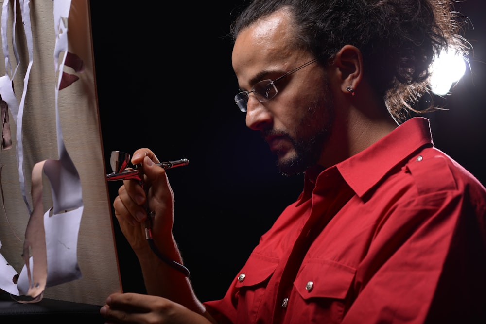 man in red button up shirt smoking cigarette