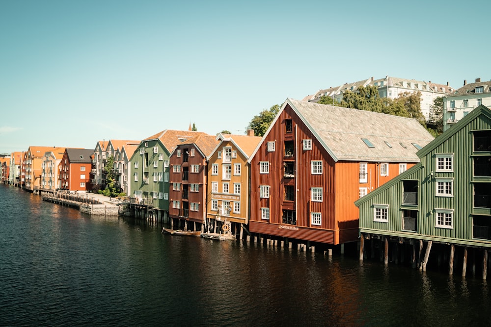 green and brown wooden houses beside river during daytime