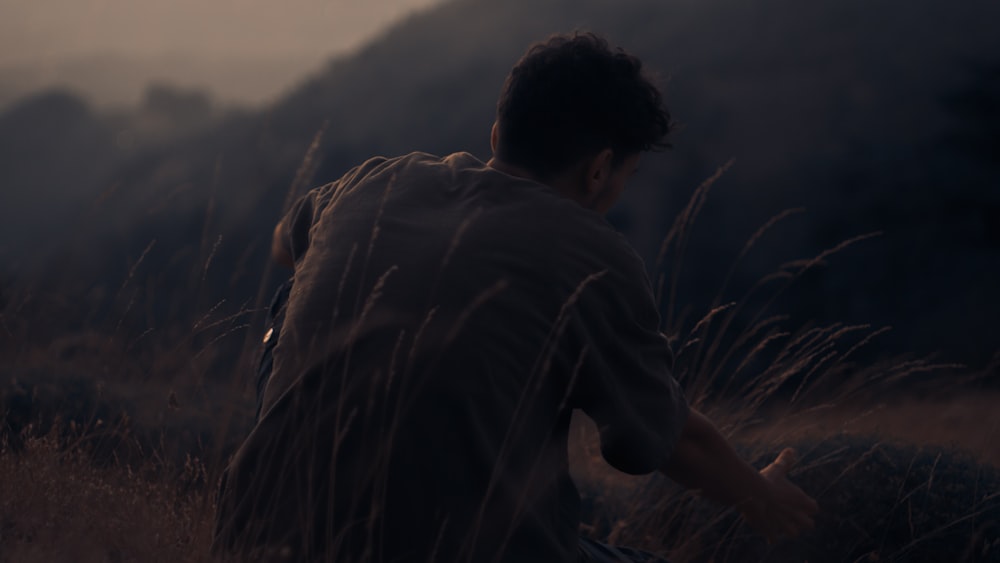 man in black jacket standing on brown grass during daytime