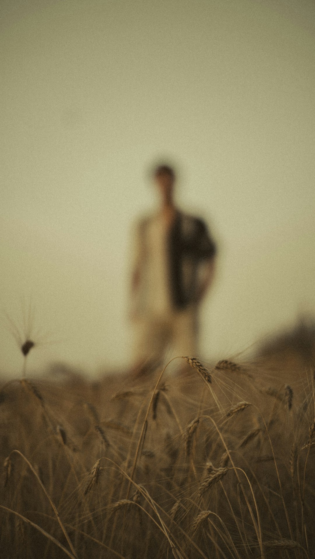 man in black jacket standing on brown grass field during daytime